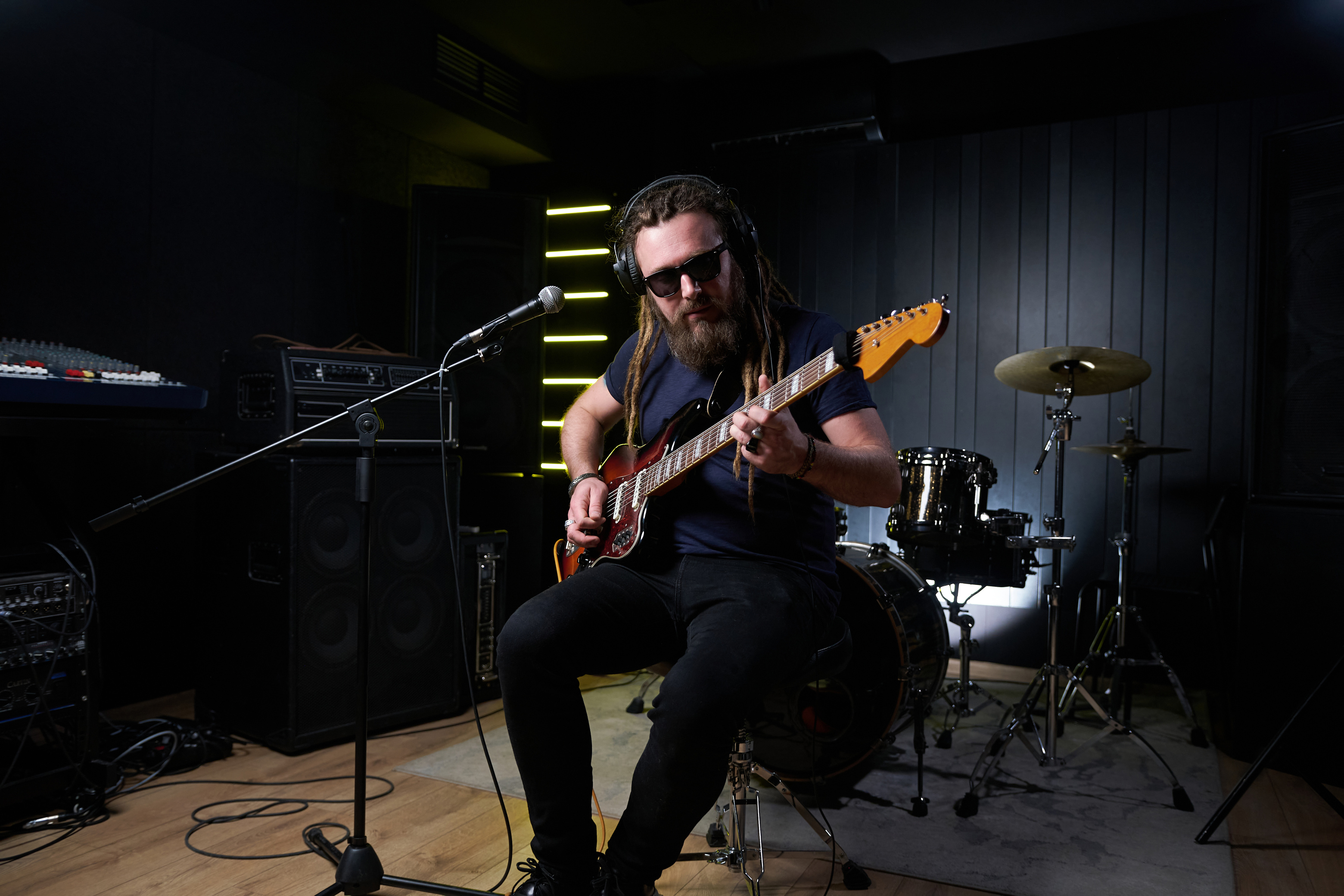 Guitarist man plays an electric guitar Close-up at studio